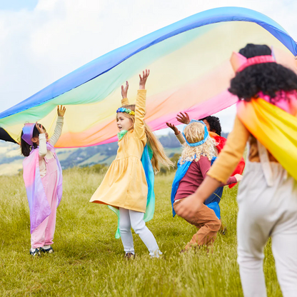Children outside in garden hands up looking upwards over them a colorful canopy sarasilk
